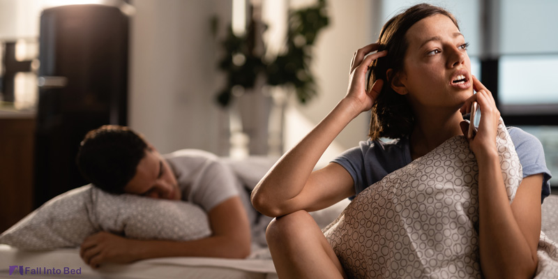 woman talking while man is in fake sleep