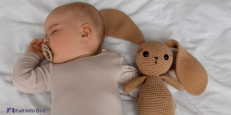 baby sleeping near plushie